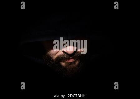 Man with a hood in the dark Stock Photo