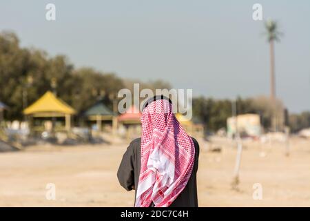 A Saudi Arabian man wearing traditional arabian clothes with background of the corniche park in Dammam, Kingdom of Saudi Arabia Stock Photo