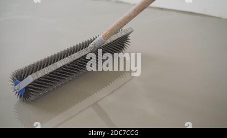 Charcoal roller on the self-leveling floor. Charcoal roller. Self-leveling floor tool. Self-leveling epoxy. Leveling with a mixture of cement floors Stock Photo