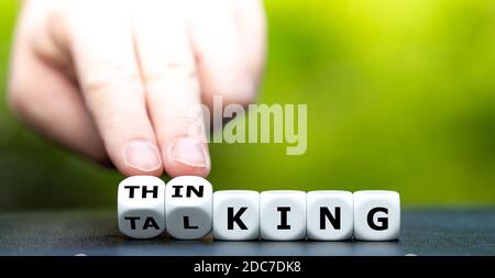 Symbol for thinking first and then talking. Hand turns dice and changes the word 'talking' to 'thinking'. Stock Photo