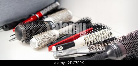 Set of different hair brushes and combs lying on the white table Stock Photo
