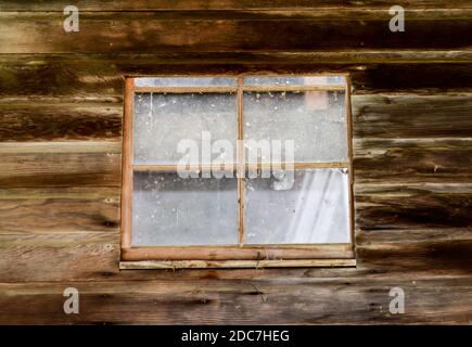 weathered wooden window on old vintage farm shed and barn Stock Photo