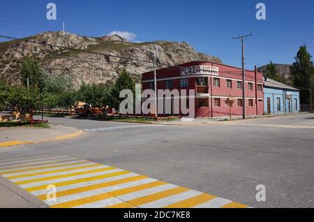 Chile Chico, Ayse, Chile - March, 2020: Pedestrian with yellow and white stripes on empty crossroad. Plaza Hotel building on corner of streets Stock Photo