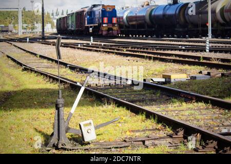railway station, rails in the foreground, the locomotive in the distance. Stock Photo