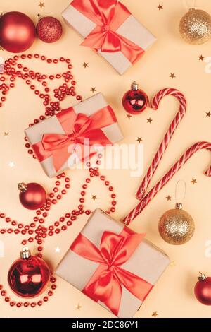 Christmas and New Year backdrop. Festively decorated  Gift boxes,  cane lollypops, christmas balls on golden banner. Stock Photo