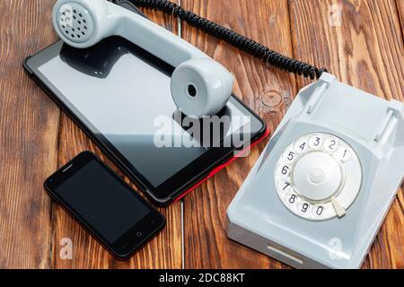 vintage phone on the background of modern gadgets. Stock Photo