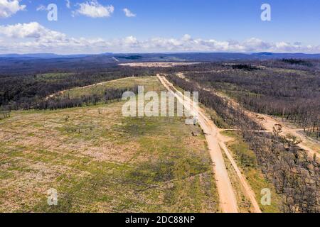 Aerial view of a dirt road running through a forest affected by bushfire in the Central Tablelands in regional New South Wales in Australia Stock Photo