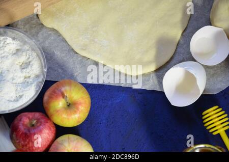 Various ingredients for winter seasonal baking and other recipes, honey, apples, herbs and spices on a dark blue background. Top view. Stock Photo