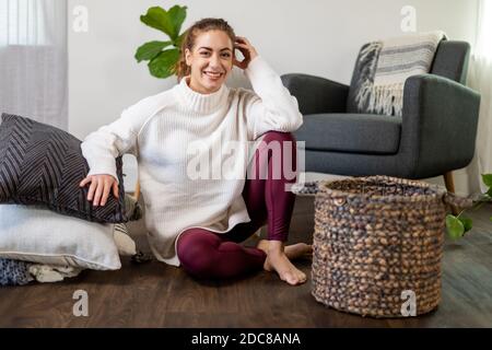 Woman sits with her stack of pillows on the floor Stock Photo