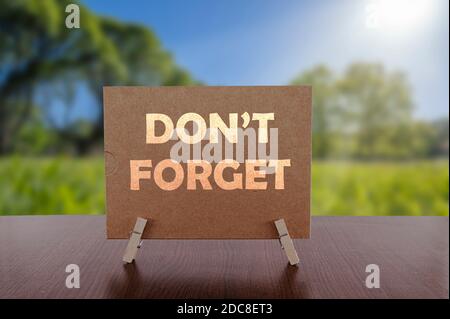 Don't forget card on the table with sunny green forest background. Stock Photo