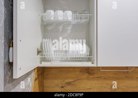set of plates, cups on the shelf in the kitchen cabinet Stock Photo