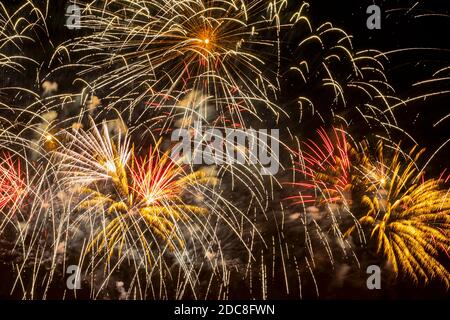 Fireworks display against the night sky. Flying sparks, colorful colored smoke. Holiday vivid background Stock Photo