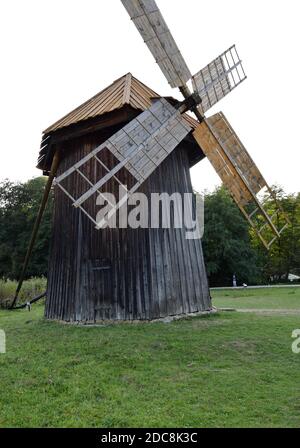 Amazing old wood vintage wooden windmill with a green field in front.Traditional old rustic mill in the countryside. Stock Photo
