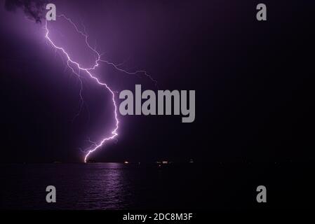 Lightning bolt hits the water during a severe thunderstorm Stock Photo