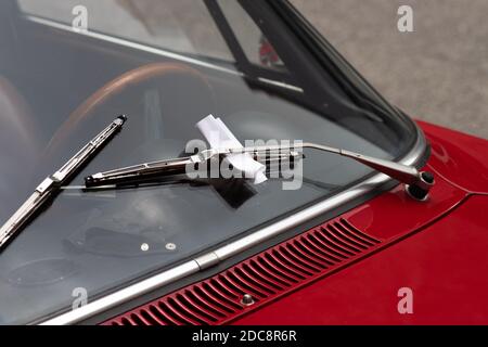 Closeup of a parking violation ticket behind a windshield wiper on a classic car Stock Photo