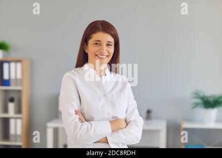 Portrait of young smiling woman office worker manager in white official shirt Stock Photo