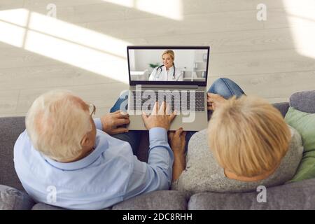 Senior couple sitting on sofa with laptop and having medical consultation with online doctor Stock Photo