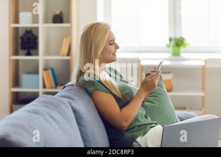 Young smiling blonde woman office worker sitting in office with notebook and pen Stock Photo