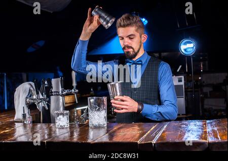 Expert Female bartender pouring fresh alcoholic drink into the glasses in the nightclub Stock Photo