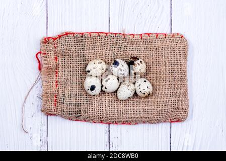 Quail eggs on burlap cloth bag. Group of quail eggs close-up. Top view. Detailed closeup of spotted quail eggs Stock Photo
