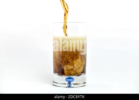 Pouring soda pop into clear glass Stock Photo