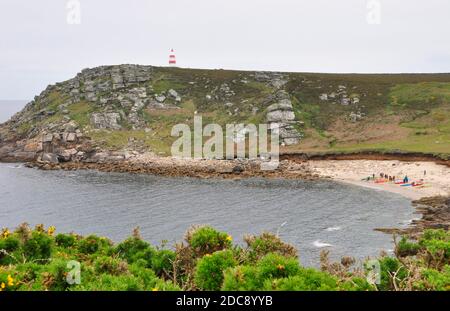 a group of canoeists rest on the beach in Bread and Cheese Cove below the Day mark on the island of St Martin's in the Isles of Scilly, Cornwall.UK Stock Photo