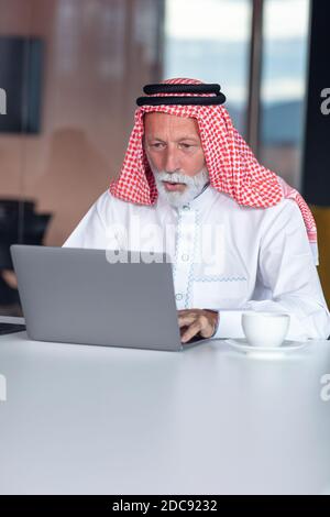 Arab businessman looks surprised while using a laptop Stock Photo
