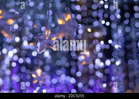 Rain of bokeh lights and star shaped ornaments with a dark bluish background Stock Photo