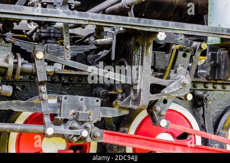 Closeup view of an old iron locomotive chassis with red wheels Stock Photo