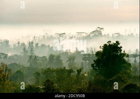 View Over Early Morning Mist on the Kedu Plain During Sunrise at Borobudur Temple, Yogyakarta, Java, Indonesia, Asia, background with copy space Stock Photo