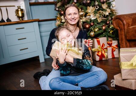 Mother gives Christmas gift to his little son for a New Year. Mom and son  opening Christmas presents Stock Photo - Alamy