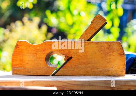 A wooden planer for processing wood is on the table on a sunny day. Stock Photo