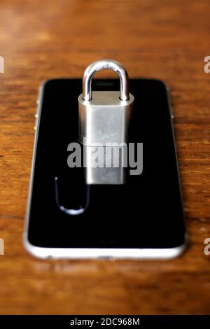 Cell phone with a closed padlock that is reflected on the screen like an open padlock. Security and vulnerability concept Stock Photo