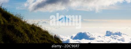 Panoramic Landscape Photo of Mount Agung, the Tallest Volcano on Bali, Rising High Above the Clouds from the Campsite on Day One of the Three Day Mount Rinjani Trek, Lombok, Indonesia, Asia, background with copy space