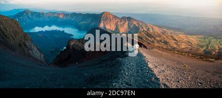 Panoramic Photo of a Tourist on the Final Push to the 3726m Summit of Mount Rinjani at Sunrise, Indonesia, Asia Stock Photo