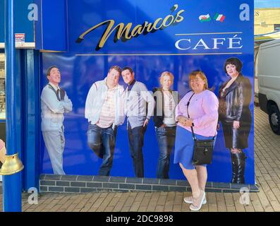 Tourist by Marco's Cafe sign (featured in 'Gavin & Stacey' sitcom), Barry Island, Barry, Vale of Glamorgan, Wales (Cymru), United Kingdom Stock Photo