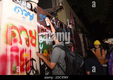 Bangkok, Thailand. 18th Nov, 2020. Anti-government protesters Gathered at the Ratchaprasong intersection Before marching in front of the Royal Thai Police Headquarters, Rama I Road, with riot police preparing to prevent intruders entering the headquarters. The protesters spray paint various messages along the way. And protesters have splashed paint on the banner of the Police Headquarters in Bangkok 18 Nov 2020. (Photo by Teera Noisakran/Pacific Press/Sipa USA) Credit: Sipa USA/Alamy Live News Stock Photo