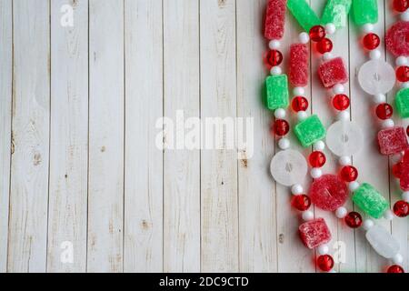 Sugar Christmas candy garland on a white wood background, right aligned, useful for holiday backgrounds Stock Photo