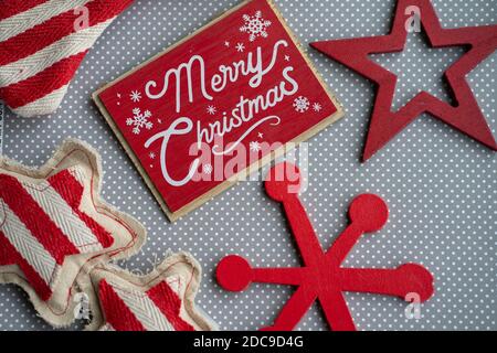 Merry Christmas red flatlay with wood and fabric snowflake decorations on a gray and white polka dot background Stock Photo