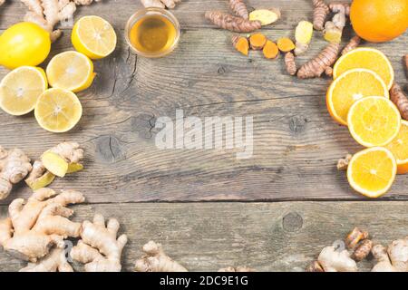 Ingredients for ginger shot recipe. Immunity boosting components for ginger drink. On the old wooden table. Citrus fruits, turmeric, ginger and honey Stock Photo