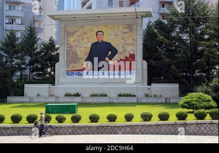 08.08.2012, Pyongyang, , North Korea - An everyday street scene shows a memorial plaque with the portrait of Kim Il-sung and houses in the background. Stock Photo