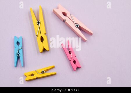 Colorful mini clothespins on a purple background Stock Photo