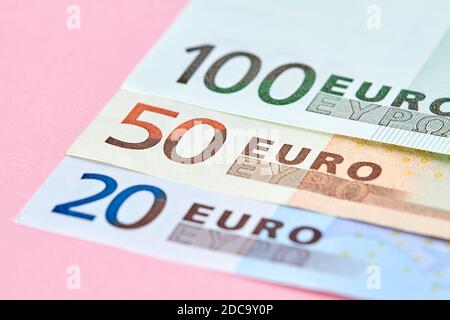 20, 50, 100 Euro banknotes on pink background. Close-up, selective focus Stock Photo