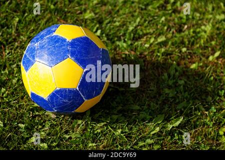 yellow and blue football on green grass Stock Photo
