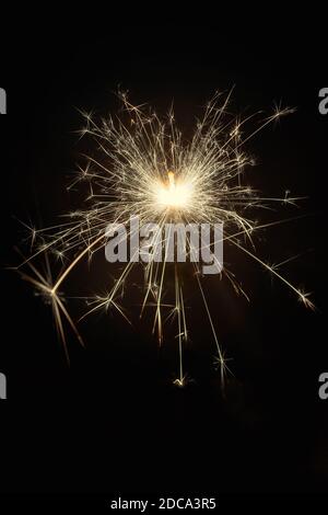Glittering burning sparkler on black background Stock Photo