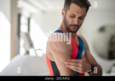 Young dark-haired man showing his biceps and feeling strong Stock Photo