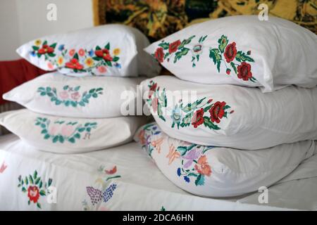 Pillows with embroidered pillowcases on the bed Stock Photo