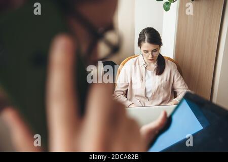 Caucasian business couple working from home on tablet and laptop while talking on phone Stock Photo