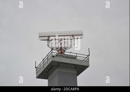 an air traffic control tower with radar, grey sky background Stock Photo