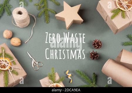Concept Zero waste Merry Christmas. Boxes, craft paper, twine, scissors, dried oranges and natural decor for wrapping XMAS, New Year gifts on green ba Stock Photo